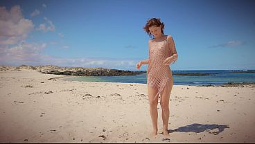 Cute girl in gold fisher net on public beach undressing and bending over